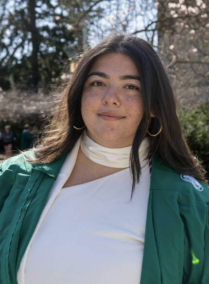 Headshot photo of Alivia Ybarra standing in front of clock tower